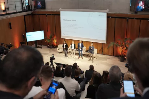 Blick auf die Bühne auf der ein Panel Talk zwischen KI-Experten stattfindet