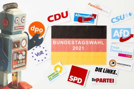 Bildcollage: Ein Roboter platziert Logos vieler deutschen Parteien um eine Deutschlandflagge